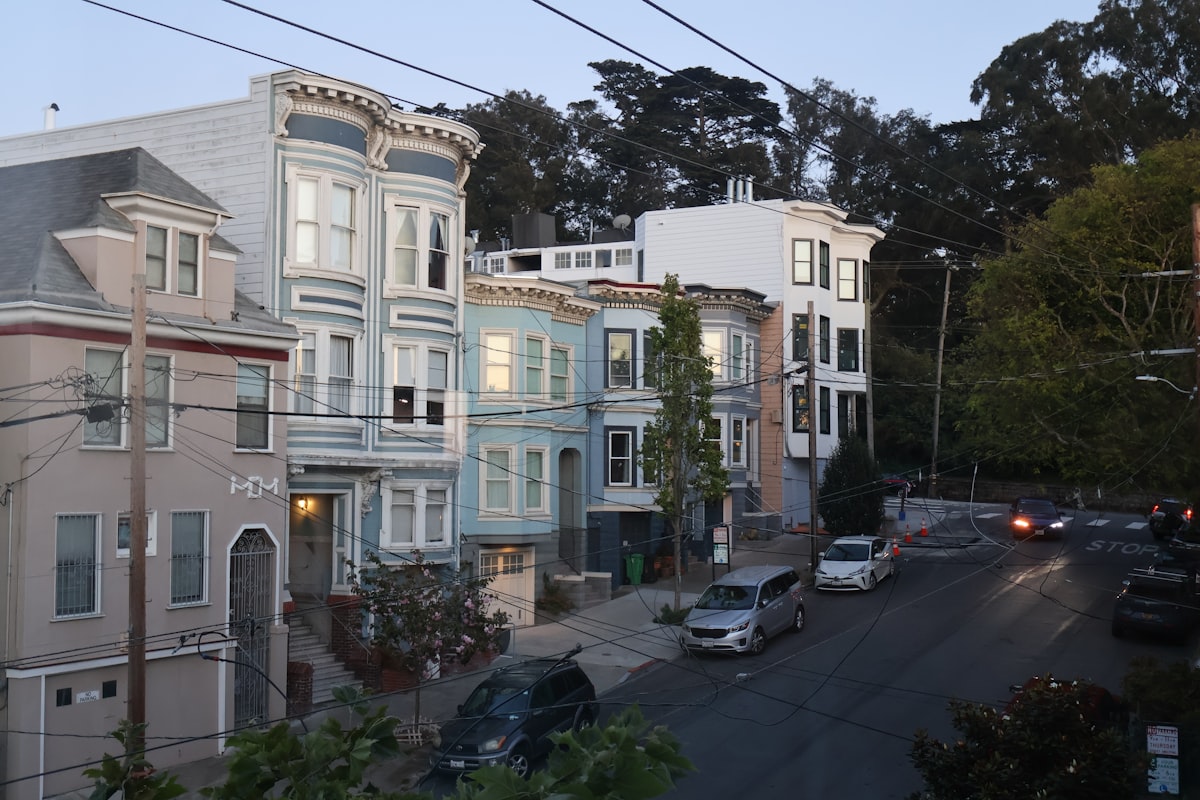 Victorian homes on a quiet tree-lined San Francisco street at dusk